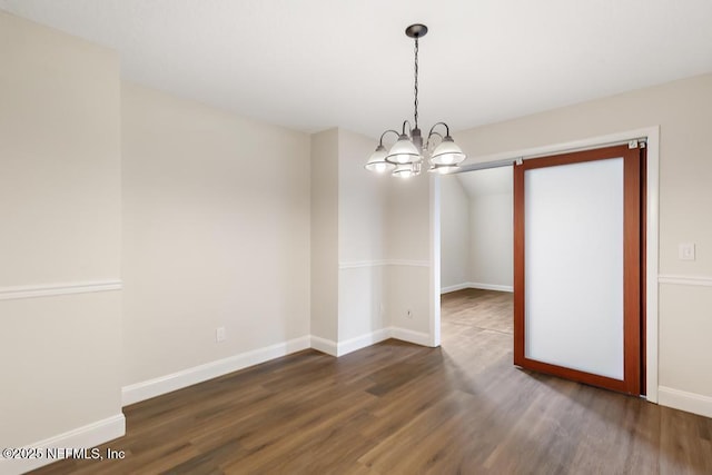 2605 Spreading Oaks Ln, Jacksonville, FL 32223 - spare room featuring a chandelier, wood finished floors, and baseboards