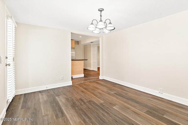 2605 Spreading Oaks Ln, Jacksonville, FL 32223 - spare room with a chandelier, baseboards, and dark wood-type flooring