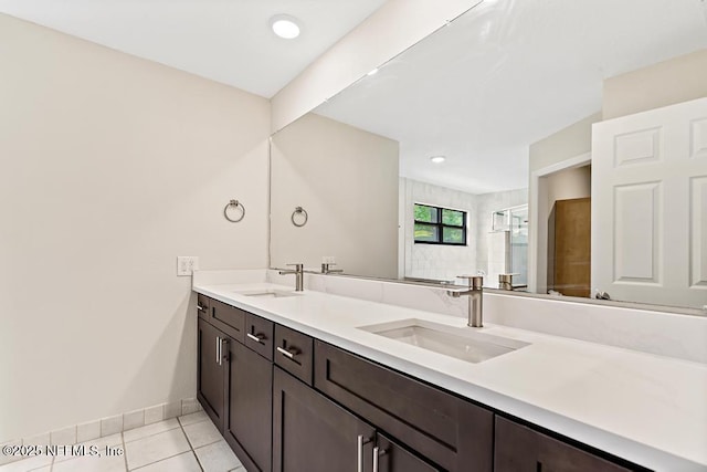 2605 Spreading Oaks Ln, Jacksonville, FL 32223 - bathroom with double vanity, tile patterned flooring, baseboards, and tiled shower