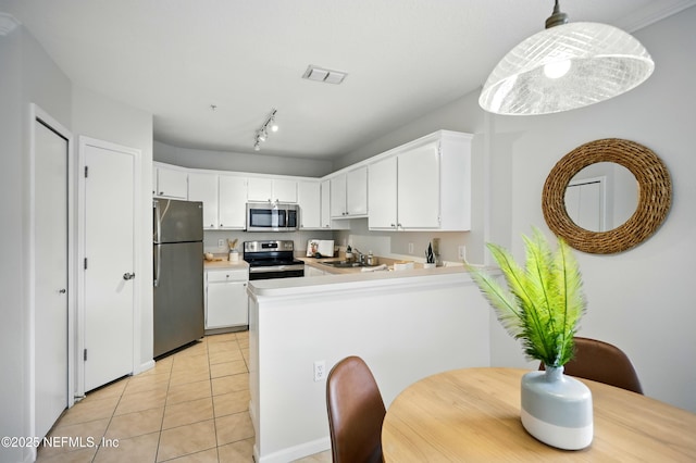 1655 The Greens Way Unit 2612, Jacksonville Beach, FL 32250 - kitchen with appliances with stainless steel finishes, a peninsula, light tile patterned flooring, white cabinetry, and light countertops