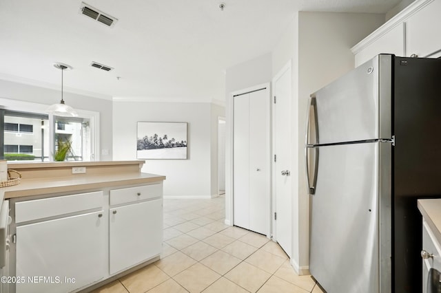 1655 The Greens Way Unit 2612, Jacksonville Beach, FL 32250 - kitchen with freestanding refrigerator, light countertops, white cabinetry, light tile patterned floors, and crown molding