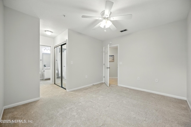 1655 The Greens Way Unit 2612, Jacksonville Beach, FL 32250 - unfurnished bedroom featuring light carpet, baseboards, ensuite bath, a closet, and ceiling fan