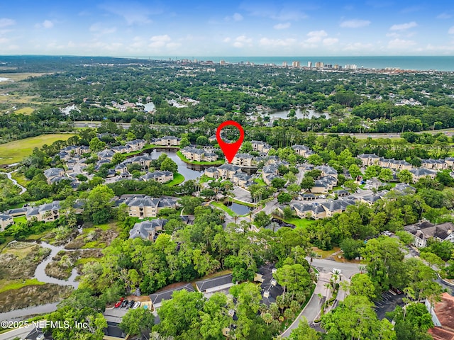 1655 The Greens Way Unit 2612, Jacksonville Beach, FL 32250 - aerial view of property and surrounding area featuring a nearby body of water, nearby suburban area, and a tree filled landscape