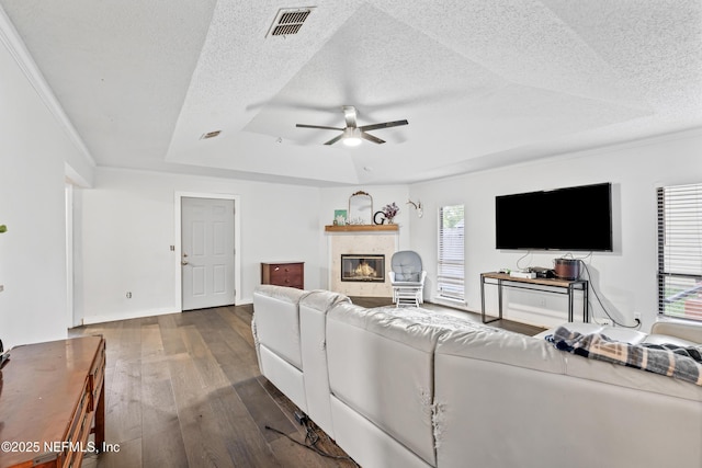 918 Arkenstone Dr, Jacksonville, FL 32225 - living room with a raised ceiling, a textured ceiling, hardwood / wood-style floors, ceiling fan, and a glass covered fireplace