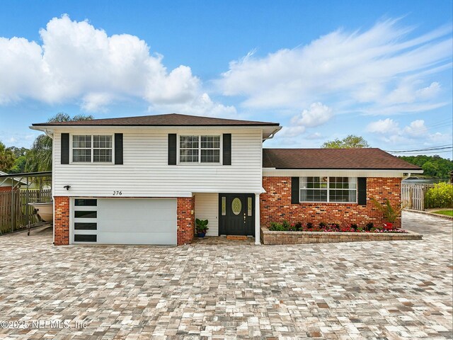 276 Baisden Rd, Jacksonville, FL 32218 - view of front facade with a garage, brick siding, and driveway