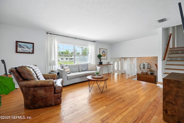 276 Baisden Rd, Jacksonville, FL 32218 - living room featuring light wood-style flooring, stairs, and a textured ceiling