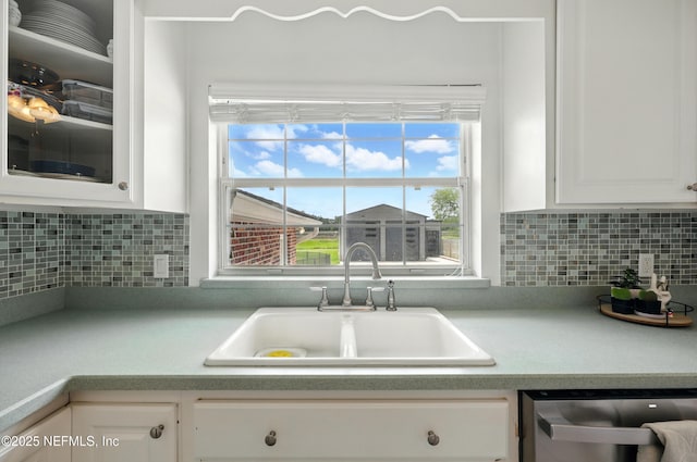 276 Baisden Rd, Jacksonville, FL 32218 - kitchen with a sink, dishwasher, white cabinetry, light countertops, and decorative backsplash