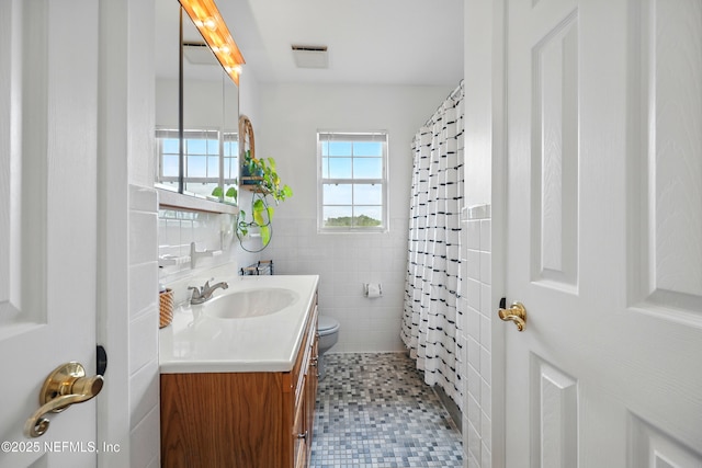 276 Baisden Rd, Jacksonville, FL 32218 - full bathroom featuring vanity, tile walls, toilet, a shower with curtain, and a wainscoted wall