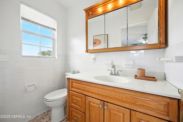 276 Baisden Rd, Jacksonville, FL 32218 - bathroom featuring vanity, tile walls, a ceiling fan, toilet, and a wainscoted wall