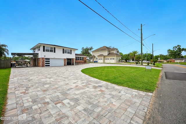 276 Baisden Rd, Jacksonville, FL 32218 - view of front facade with curved driveway, brick siding, a front yard, and a carport