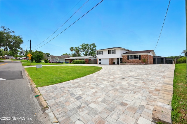 276 Baisden Rd, Jacksonville, FL 32218 - split level home featuring decorative driveway, brick siding, a front yard, and an attached garage
