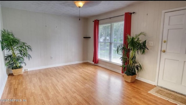 1010 N 15th St, Fernandina Beach, FL 32034 - empty room featuring light wood-style floors, baseboards, and wooden walls