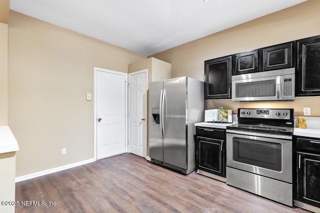 7990 Baymeadows Rd E Unit 2006, Jacksonville, FL 32256 - kitchen featuring appliances with stainless steel finishes, dark cabinets, wood finished floors, light countertops, and baseboards
