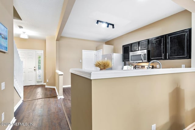 7990 Baymeadows Rd E Unit 2006, Jacksonville, FL 32256 - kitchen featuring stainless steel microwave, dark cabinetry, freestanding refrigerator, dark wood-style flooring, and a peninsula