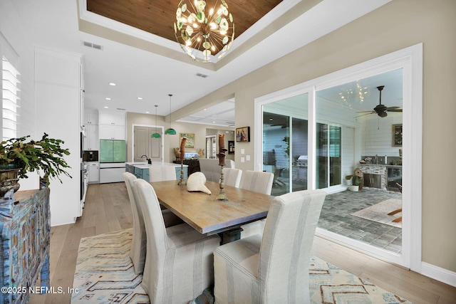 71 Deer Ridge Dr, Ponte Vedra, FL 32081 - dining area featuring a chandelier, a tray ceiling, light wood-type flooring, and plenty of natural light