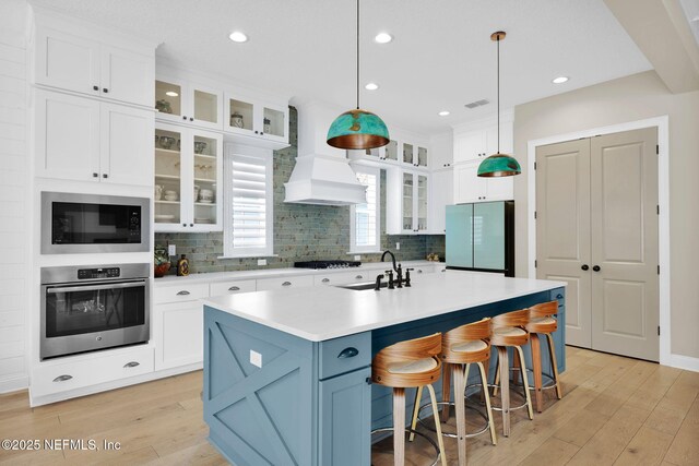 71 Deer Ridge Dr, Ponte Vedra, FL 32081 - kitchen featuring stainless steel oven, a sink, freestanding refrigerator, premium range hood, and built in microwave