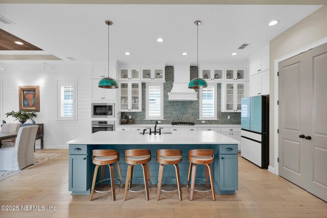 71 Deer Ridge Dr, Ponte Vedra, FL 32081 - kitchen with freestanding refrigerator, custom range hood, built in microwave, light countertops, and light wood-style floors