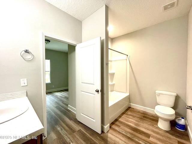 1303 Bonaventure Ave, Green Cove Springs, FL 32043 - full bathroom with vanity, wood finished floors, toilet, baseboards, and a textured ceiling