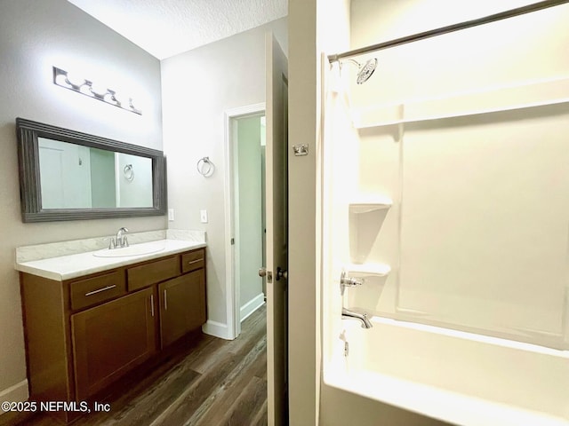1303 Bonaventure Ave, Green Cove Springs, FL 32043 - bathroom with wood finished floors, vanity, tub / shower combination, baseboards, and a textured ceiling