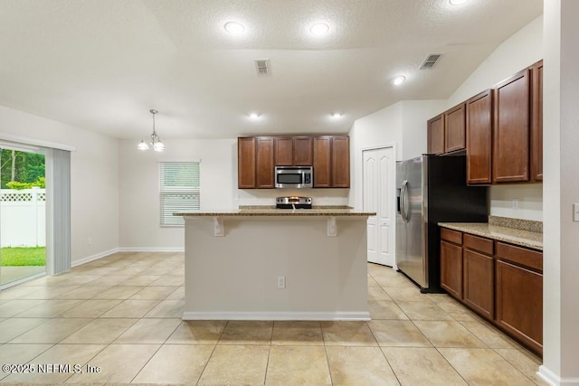 112 Glenlivet Way, Saint Johns, FL 32259 - kitchen with appliances with stainless steel finishes, light tile patterned floors, light stone countertops, a kitchen bar, and recessed lighting