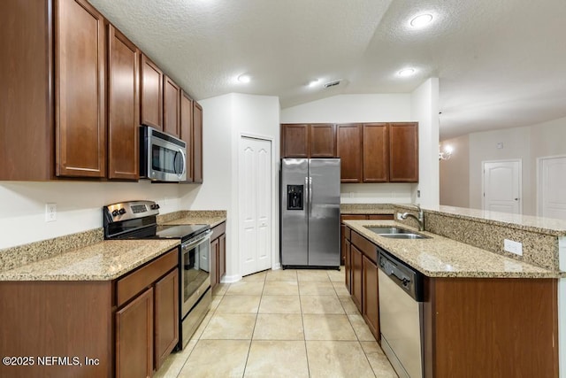 112 Glenlivet Way, Saint Johns, FL 32259 - kitchen with appliances with stainless steel finishes, vaulted ceiling, light stone countertops, a center island with sink, and light tile patterned floors
