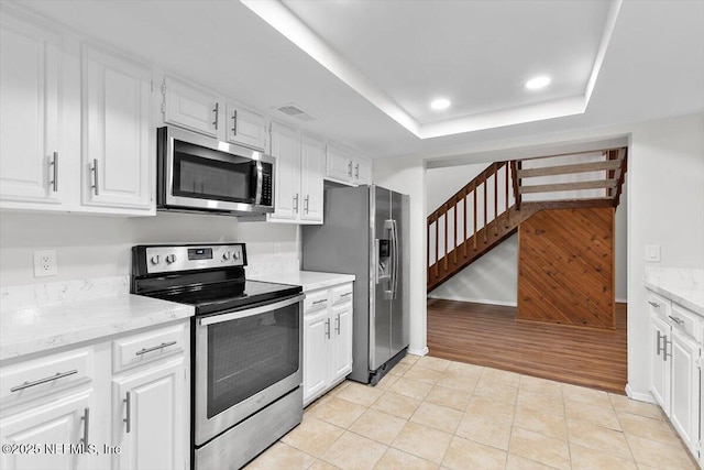 5524 Manfields Pl, Jacksonville, FL 32207 - kitchen featuring stainless steel appliances, white cabinetry, light stone counters, light tile patterned floors, and recessed lighting