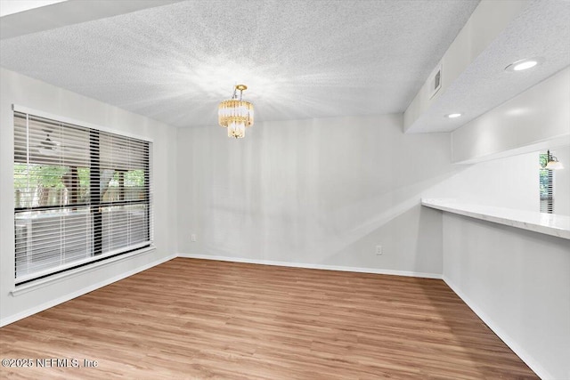 5524 Manfields Pl, Jacksonville, FL 32207 - unfurnished dining area with wood finished floors, a chandelier, a textured ceiling, baseboards, and recessed lighting