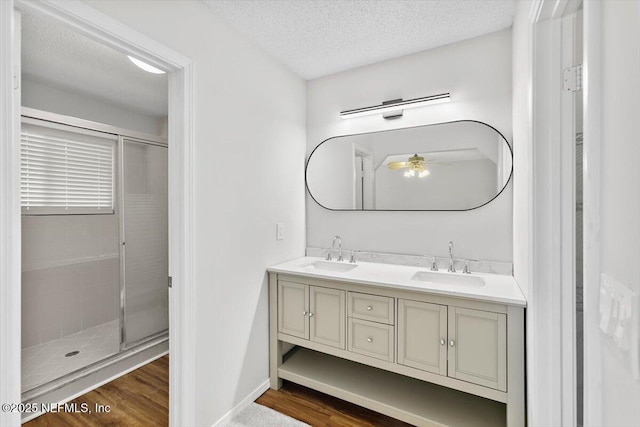 5524 Manfields Pl, Jacksonville, FL 32207 - bathroom featuring double vanity, wood finished floors, a ceiling fan, a stall shower, and a textured ceiling