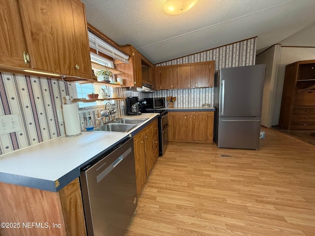 104 Waterway Ave, Satsuma, FL 32189 - kitchen featuring appliances with stainless steel finishes, a sink, vaulted ceiling, brown cabinets, and light wood-style flooring
