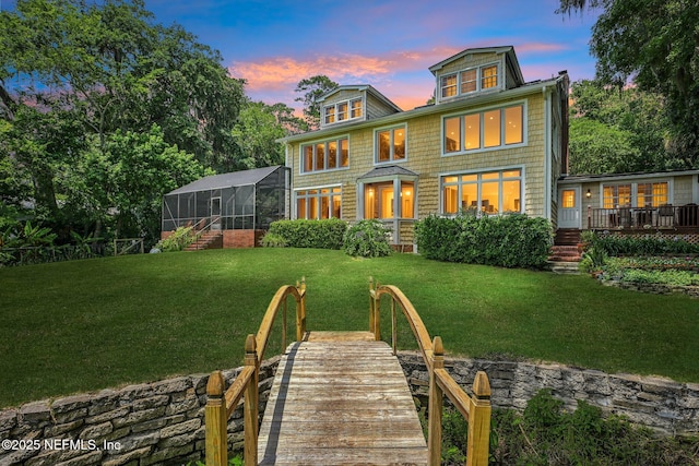 145 River Rd, Orange Park, FL 32073 - back of house at dusk featuring a lawn, a lanai, and a wooden deck