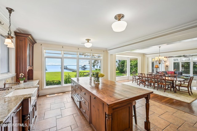 145 River Rd, Orange Park, FL 32073 - kitchen featuring wooden counters, crown molding, brown cabinets, hanging light fixtures, and a chandelier