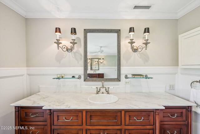 145 River Rd, Orange Park, FL 32073 - bathroom with crown molding, vanity, ceiling fan, a decorative wall, and a wainscoted wall