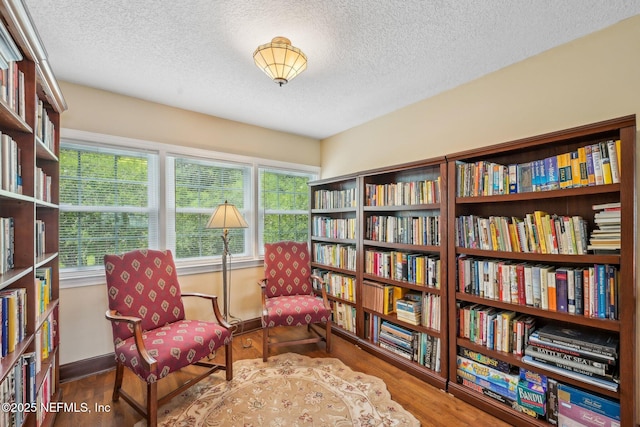 145 River Rd, Orange Park, FL 32073 - sitting room with wall of books, a textured ceiling, wood finished floors, and baseboards