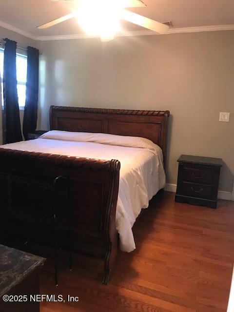 2404 Crill Ave, Palatka, FL 32177 - bedroom featuring ornamental molding, wood finished floors, and baseboards