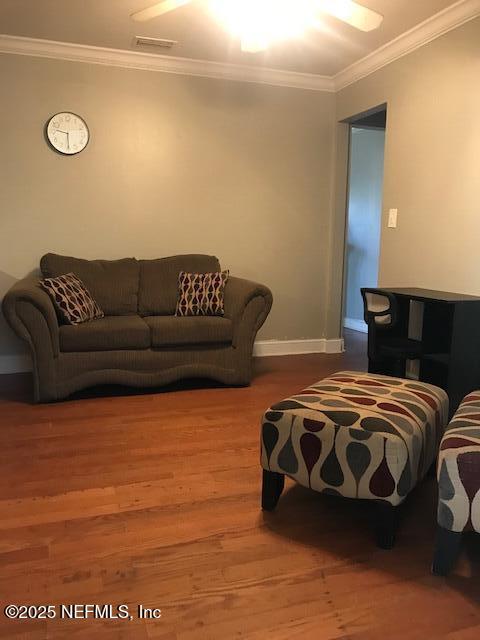 2404 Crill Ave, Palatka, FL 32177 - living room with crown molding, wood finished floors, and baseboards