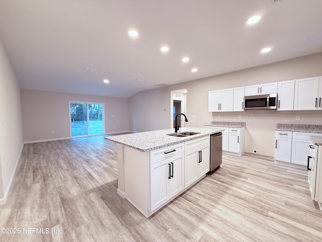 6971 Como Rd, Jacksonville, FL 32210 - kitchen featuring a sink, stainless steel appliances, light wood finished floors, light stone countertops, and white cabinetry