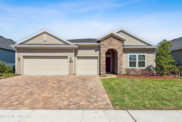 2724 White Cedar Ln, Green Cove Springs, FL 32043 - craftsman-style house featuring decorative driveway, a front yard, a garage, and stone siding
