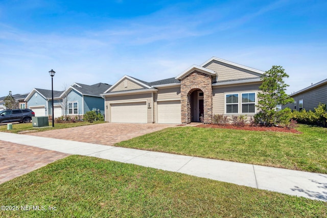 2724 White Cedar Ln, Green Cove Springs, FL 32043 - ranch-style house with decorative driveway, stone siding, an attached garage, and a front yard