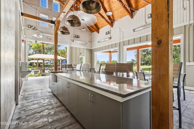 2724 White Cedar Ln, Green Cove Springs, FL 32043 - kitchen featuring high vaulted ceiling, a sink, gray cabinetry, baseboards, and dark countertops