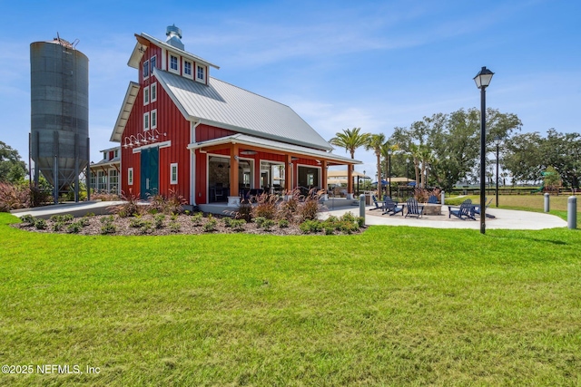 2724 White Cedar Ln, Green Cove Springs, FL 32043 - rear view of property featuring a patio, a lawn, metal roof, and board and batten siding