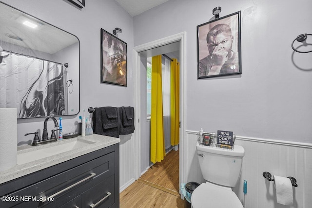 734 N Walnut St, Starke, FL 32091 - full bathroom featuring wood finished floors, vanity, toilet, and wainscoting