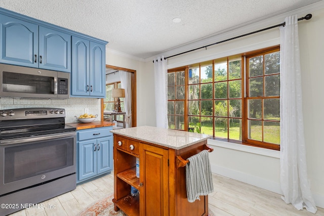 17459 Eagle Bend Blvd, Jacksonville, FL 32226 - kitchen featuring appliances with stainless steel finishes, blue cabinetry, a textured ceiling, light wood-style floors, and tasteful backsplash