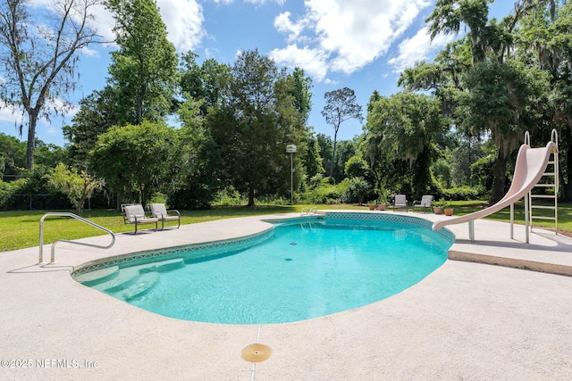 17459 Eagle Bend Blvd, Jacksonville, FL 32226 - outdoor pool with a water slide, a patio area, a lawn, and view of wooded area