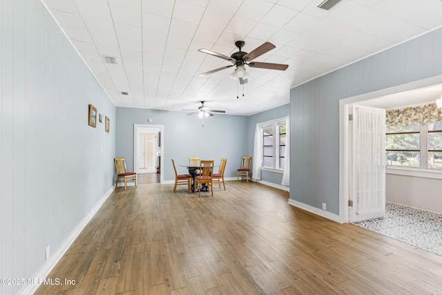 2505 State St, Palatka, FL 32177 - dining area featuring a ceiling fan, wood finished floors, wooden walls, and baseboards