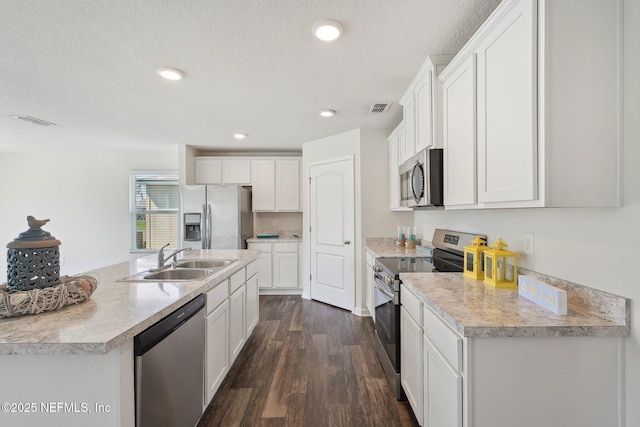 96 Cody St, Saint Augustine, FL 32084 - kitchen featuring appliances with stainless steel finishes, a sink, dark wood finished floors, white cabinetry, and a textured ceiling