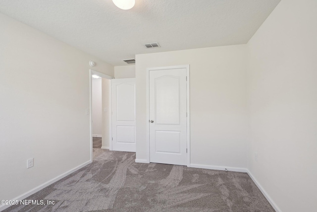 96 Cody St, Saint Augustine, FL 32084 - unfurnished bedroom featuring carpet flooring, baseboards, and a textured ceiling