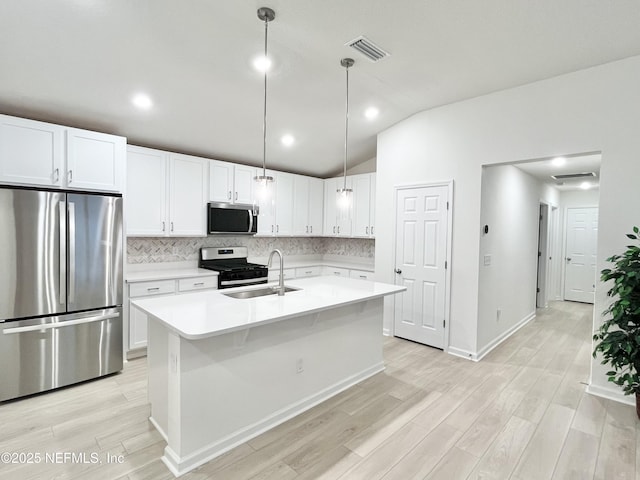 354 Boulder Ln, Saint Johns, FL 32259 - kitchen featuring stainless steel appliances, a sink, vaulted ceiling, light wood-style flooring, and backsplash