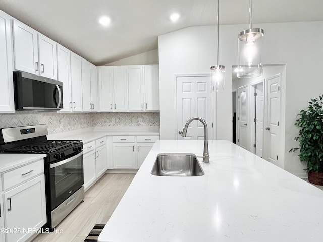 354 Boulder Ln, Saint Johns, FL 32259 - kitchen with stainless steel appliances, a sink, light wood-style flooring, decorative backsplash, and lofted ceiling