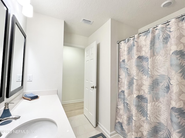 354 Boulder Ln, Saint Johns, FL 32259 - full bath with vanity, a textured ceiling, a shower with shower curtain, and baseboards