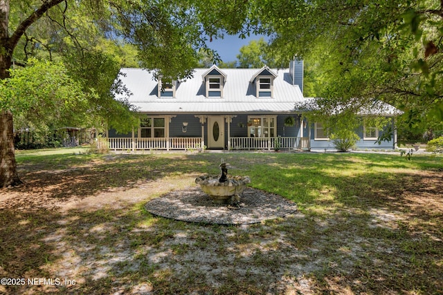 2708 Poinsettia Ave, Middleburg, FL 32068 - view of front of home featuring covered porch, a chimney, metal roof, and a front lawn